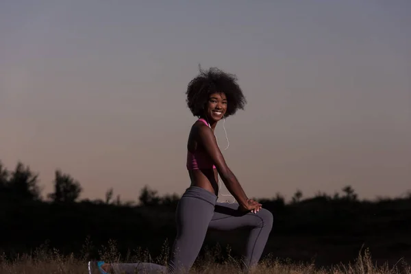 Negro mujer está haciendo estiramiento ejercicio relajante y calentar —  Fotos de Stock