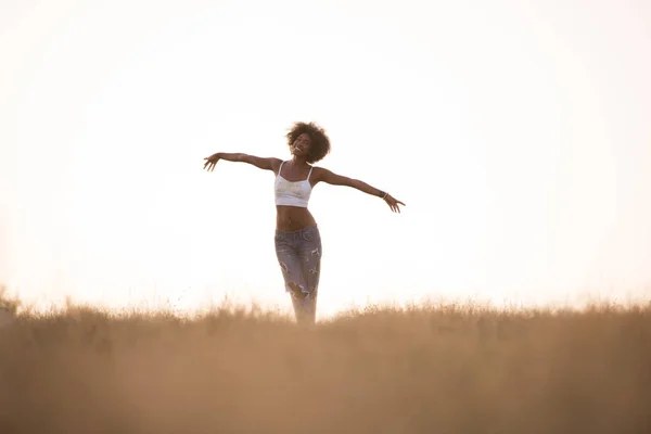 Young black girl dances outdoors in a meadow — Stock Photo, Image