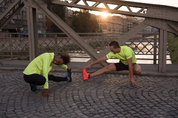 Τζόκινγκ ζευγάρι προθέρμανση και stretching στην πόλη — Φωτογραφία Αρχείου