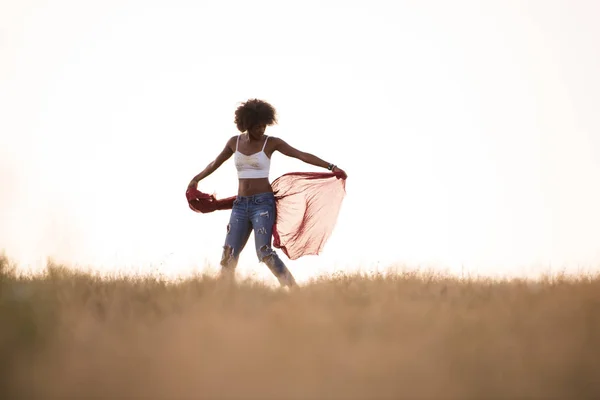 Black girl dances outdoors in a meadow — Stock Photo, Image