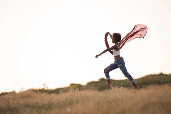 Black girl dances outdoors in a meadow — Stock Photo, Image