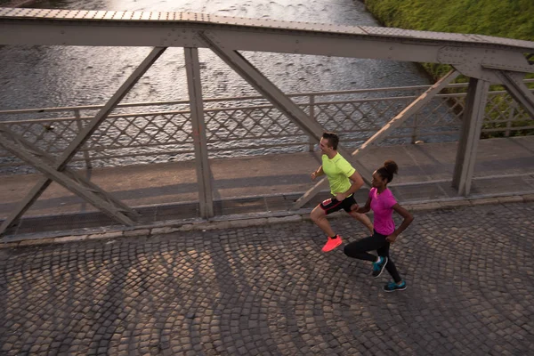 Jonge multi-etnisch paar joggen in de stad — Stockfoto