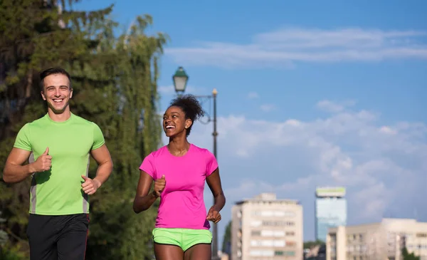 Ung leende multietniskt par jogging i staden — Stockfoto