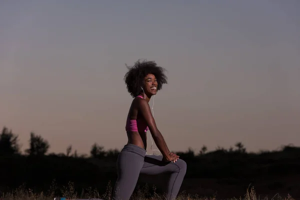 Mulher negra está fazendo alongamento exercício relaxante e aquecimento — Fotografia de Stock