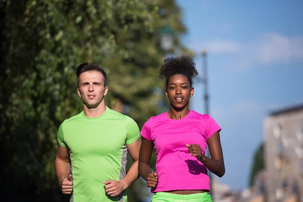 Ung leende multietniskt par jogging i staden — Stockfoto