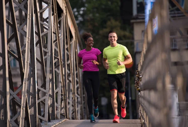 Multi-etnisch paar joggen in de stad — Stockfoto