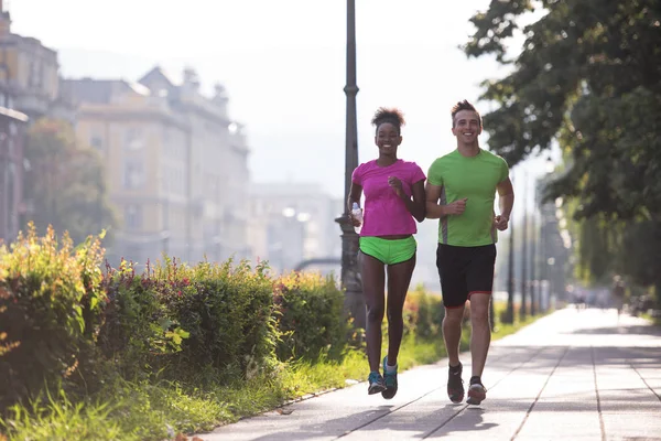 Young multiethnic couple jogging in the city — Stock Photo, Image