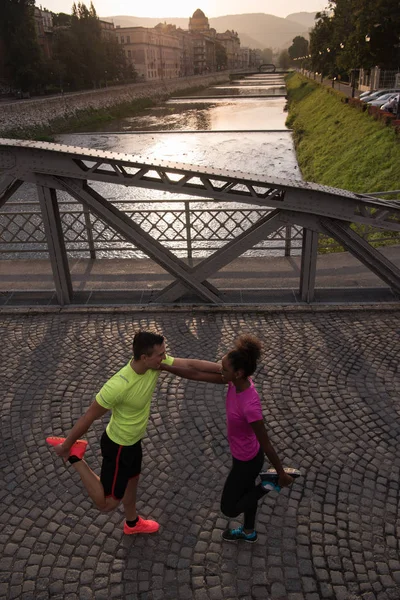 Jogging couple échauffement et étirement dans la ville — Photo