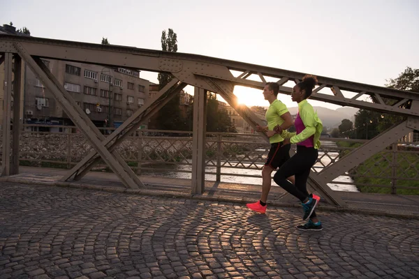 Mladý pár mnohonárodnostní běhání ve městě — Stock fotografie