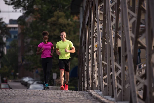 Coppia multietnica jogging in città — Foto Stock