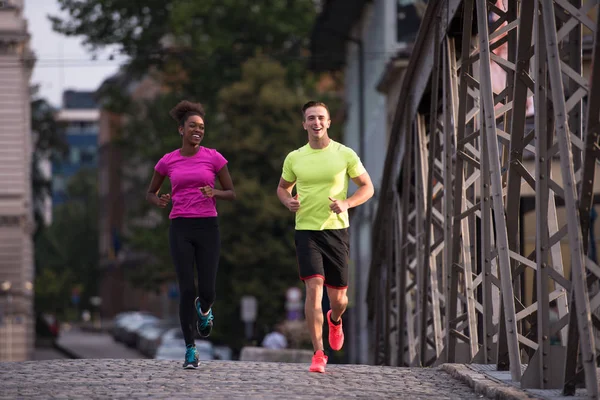 Multiethnic couple jogging in the city — Stock Photo, Image