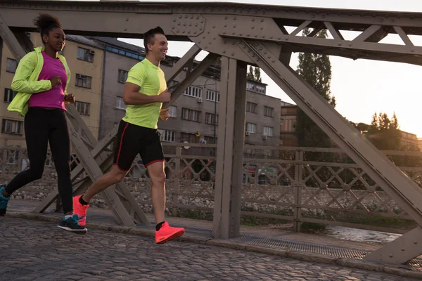 Jeune couple jogging dans la ville — Photo