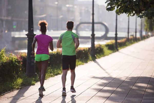 Unga multietniskt par jogging i staden — Stockfoto