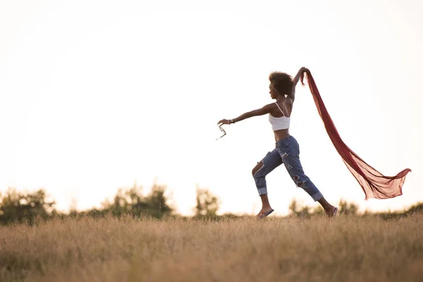 Black girl dances outdoors in a meadow — Stock Photo, Image
