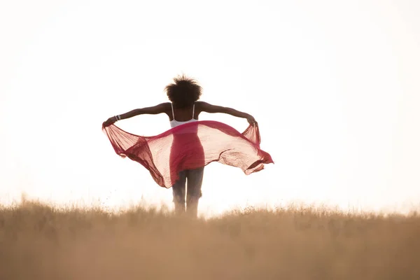 Black girl dances outdoors in a meadow — Stock Photo, Image