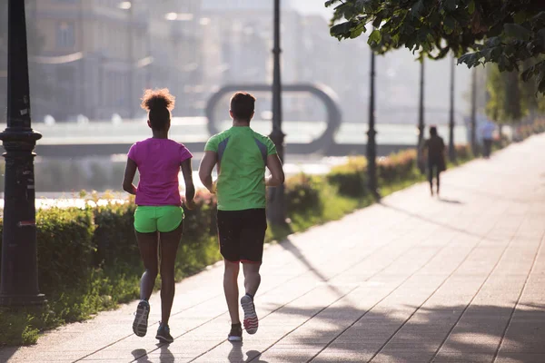 Unga multietniskt par jogging i staden — Stockfoto