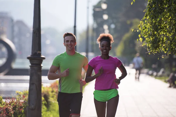 Young multiethnic couple jogging in the city — Stock Photo, Image