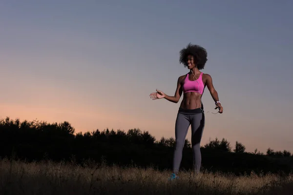 Siyah kadın rahatlatıcı ve ısınmak germe egzersiz yapıyor — Stok fotoğraf