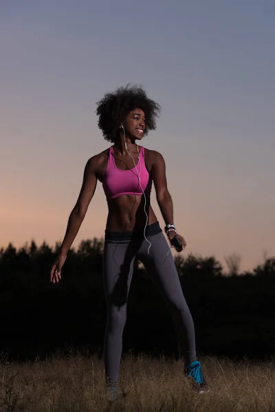 Mulher negra está fazendo alongamento exercício relaxante e aquecimento — Fotografia de Stock