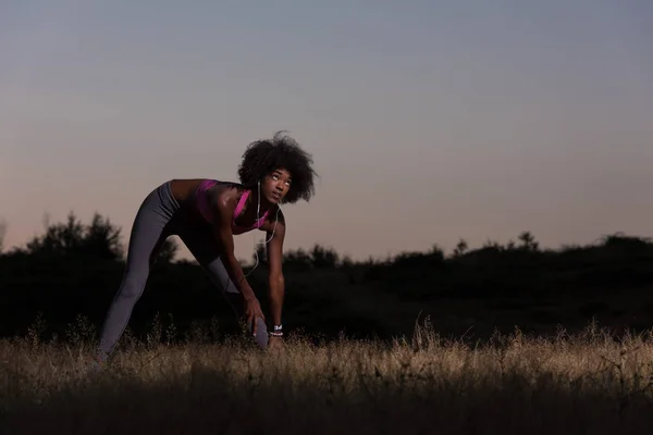 Negro mujer está haciendo estiramiento ejercicio relajante y calentar — Foto de Stock