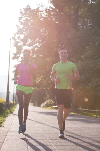 Junges multiethnisches Paar joggt in der Stadt — Stockfoto