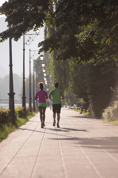 Jeune souriant couple multiethnique jogging dans la ville — Photo