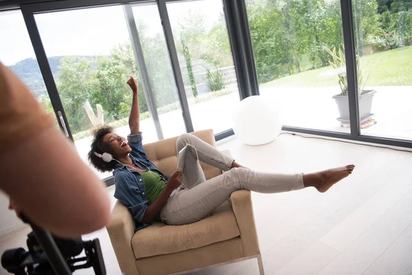 Africano americano mulher em casa na cadeira com tablet — Fotografia de Stock