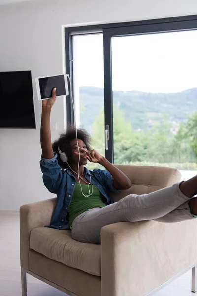 Africano americano mulher em casa na cadeira com tablet — Fotografia de Stock