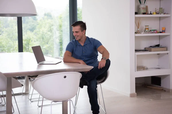 Jovem com laptop em casa — Fotografia de Stock