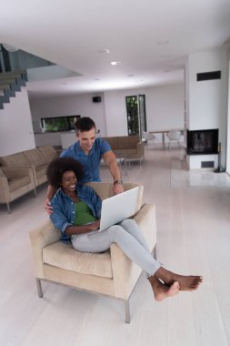 çok ırklı çift bir dizüstü bilgisayar ile bir koltuk üzerinde