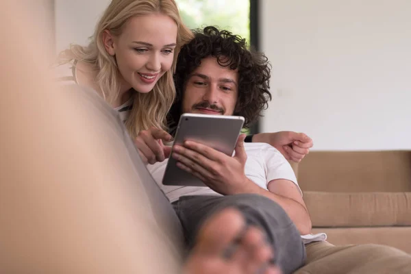 Couple relaxant à la maison avec tablettes — Photo