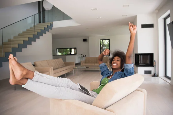 Femme afro-américaine à la maison dans une chaise avec tablette — Photo