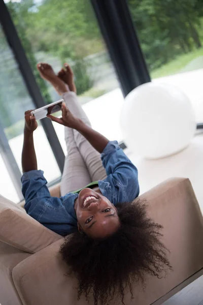 Afrikanerin zu Hause mit digitalem Tablet — Stockfoto