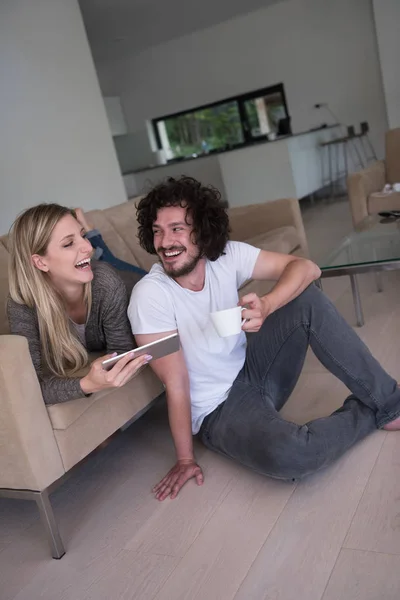 Пара розслабляється вдома з планшетними комп'ютерами — стокове фото