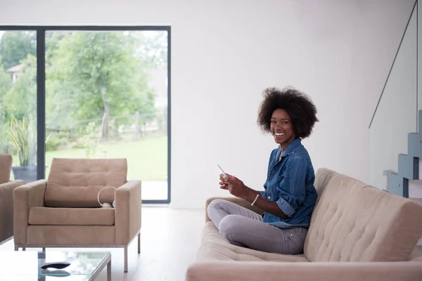 Afroamerikanska kvinna hemma med digital tablett — Stockfoto