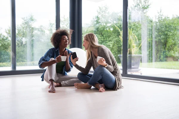 Multietniskt kvinnor sitta på golvet och dricka kaffe — Stockfoto