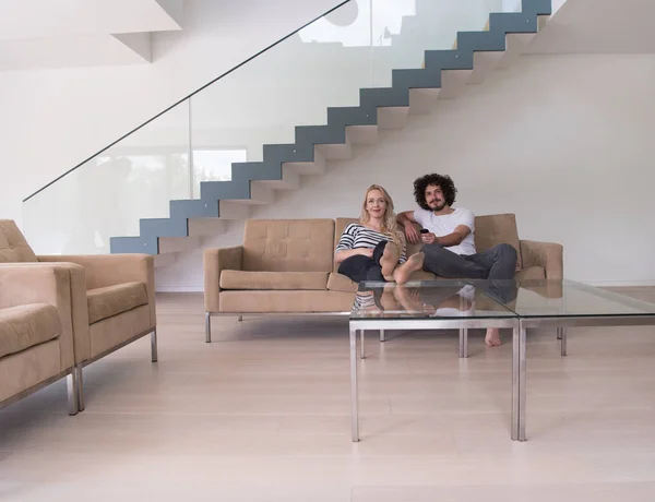 Jeune couple sur le canapé regarder la télévision — Photo