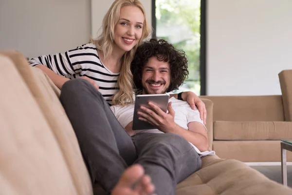 Couple relaxant à la maison avec tablettes — Photo