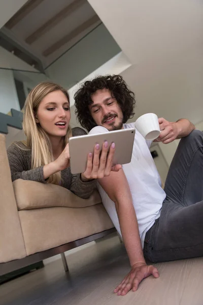 태블릿 컴퓨터와 집에서 휴식 하는 커플 — 스톡 사진