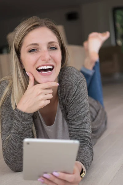 Mujer joven utiliza tableta ordenador en el suelo — Foto de Stock