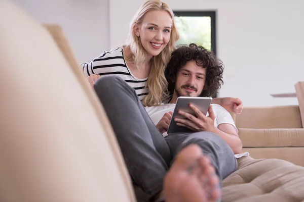 Pár v pohodlí domova u počítačů typu tablet — Stock fotografie