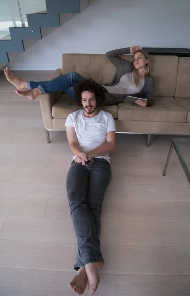 Jovem casal relaxa na sala de estar — Fotografia de Stock