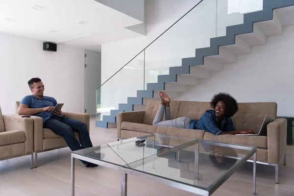 Jovem casal multiétnico relaxa na sala de estar — Fotografia de Stock
