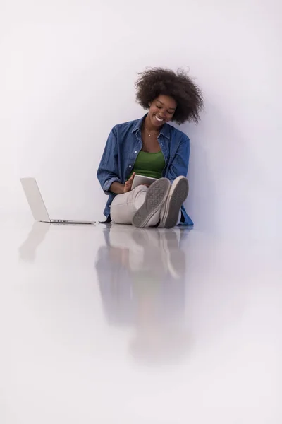 Африканская американка, сидящая на полу с ноутбуком — стоковое фото
