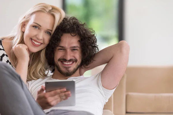 Pár v pohodlí domova u počítačů typu tablet — Stock fotografie