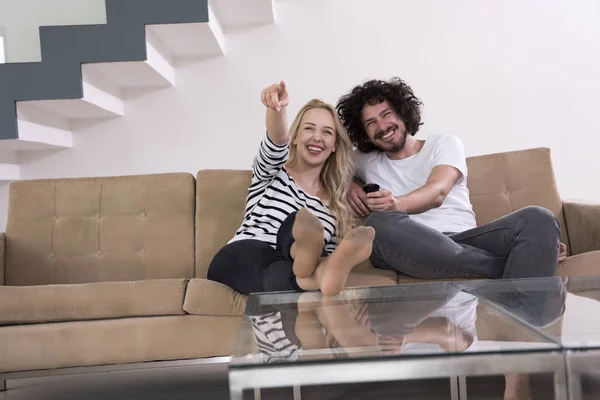 Jeune couple sur le canapé regarder la télévision — Photo