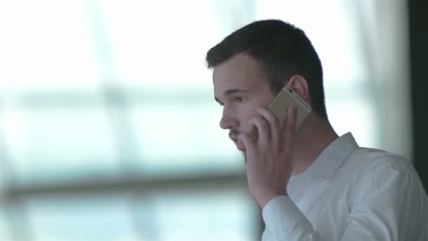 Расслабленный молодой бизнесмен говорит по смартфону — стоковое видео