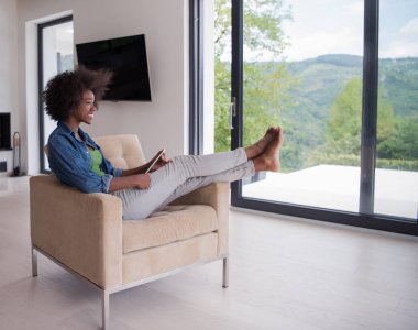 Afrikalı-Amerikalı kadın evde dijital tablet ile