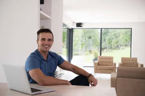 Jovem com laptop em casa — Fotografia de Stock