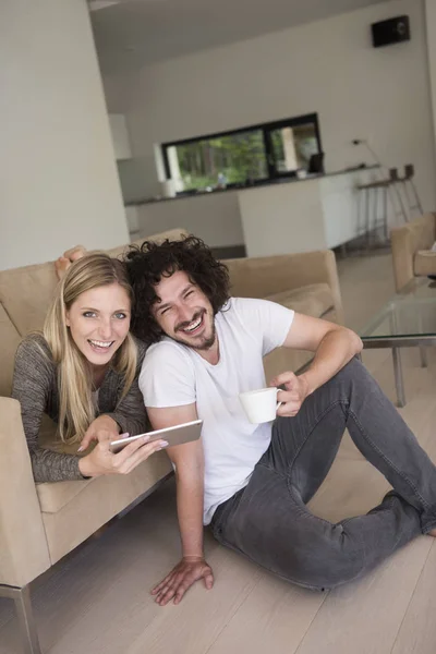 Pareja relajante en casa con tabletas —  Fotos de Stock